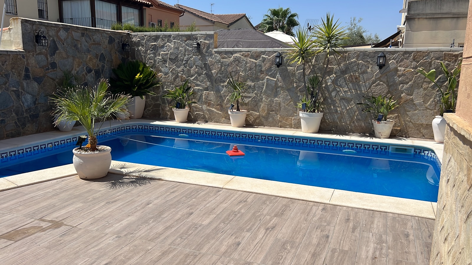 a backyard with a swimming pool surrounded by stone walls